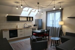 a kitchen and living room with a table and chairs at Apartamenty przy Winnicy in Busko-Zdrój