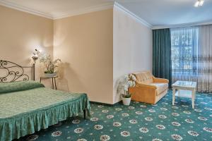 ein Schlafzimmer mit einem Bett, einem Stuhl und einem Fenster in der Unterkunft Evergreen apartments hotel in Karlsbad