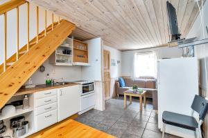 a kitchen with a white refrigerator and a staircase at Skottevik Feriesenter in Skottevik +47 photos