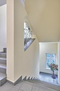 eine Treppe in einem Haus mit einer Blumenvase in der Unterkunft Evergreen apartments hotel in Karlsbad + 22 Fotos
