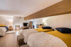 a room with three beds with white and yellow at Cocoon in Megeve in Megève