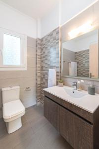 ein Badezimmer mit einem WC, einem Waschbecken und einem Spiegel in der Unterkunft Mamfredas Luxury Resort in Planos
