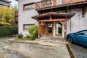 a house with a wooden porch and a car parked outside at Cocoon in Megeve in Megève