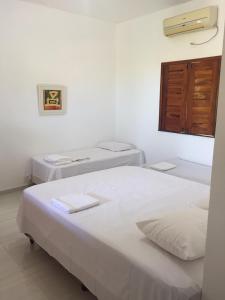 a room with two beds and a window at Batista's Beach in Luis Correia
