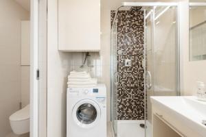 a bathroom with a washing machine and a shower at COZY&QUIET apartment with A/C in city centre in Prague
