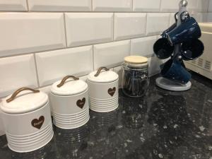 four stacks of plates sitting on a kitchen counter at 3. Stylish Private Double Room Near Manchester City Centre in Manchester