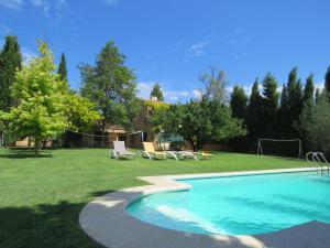 a swimming pool in a yard with chairs and trees at Costa Brava Apartment Casa Ana in Camallera