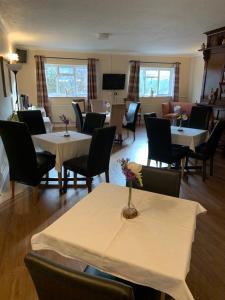 a restaurant with tables and chairs with flowers on them at Hill Lodge in Sudbury