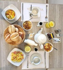 a table with plates of breakfast foods and drinks at Villa Oasis in Ica