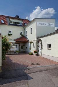 a white building with a translation city sign on it at Pension "City" in Oschatz