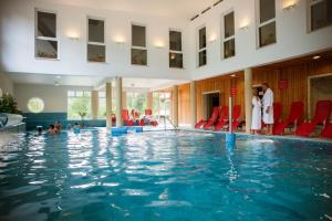 a swimming pool with people standing around it at Lobogo Resort in Vlăhiţa