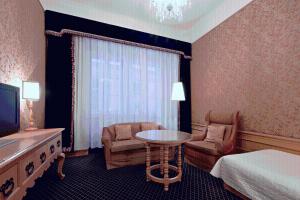 a hotel room with a bed and a table and chair at Hotel König von Ungarn in Vienna