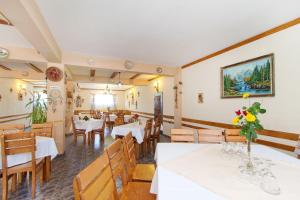ein Restaurant mit Tischen und Stühlen und einem Gemälde an der Wand in der Unterkunft Motel Evrica in Horezu