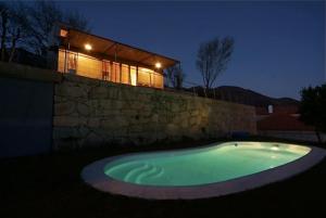 蓬蒂達巴爾卡的住宿－Casa da Cerejeira - Casas de Alem - Ecoturismo，石头墙前的大型游泳池