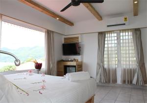 a bedroom with a bed and a large window at Le Relax Hotel and Restaurant in Anse Royale