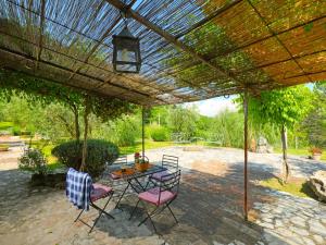 un patio con mesa y sillas bajo una pérgola en Holiday Home Nest by Interhome, en Penna in Teverina
