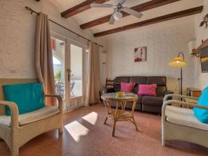 een woonkamer met een bank en een tafel en stoelen bij Apartment El Palmeral by Interhome in Denia