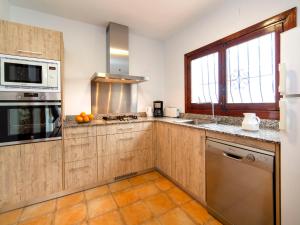 a kitchen with wooden cabinets and a sink and a microwave at Villa Bel by Interhome in Pedramala