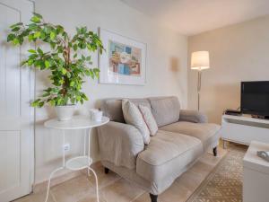 a living room with a couch and a table with a plant at Holiday Home Petite Fleur by Interhome in Montgo