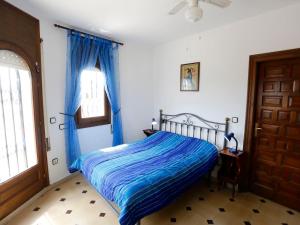 a bedroom with a bed with blue sheets and a window at Villa Philippe by Interhome in Miami Platja