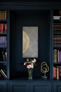 un jarrón de flores sobre una mesa en una biblioteca en Saltmarshe Hall, en Saltmarshe