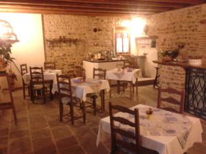 a dining room with tables and chairs and a kitchen at Alloggio Agrituristico Conte Ottelio in Pradamano