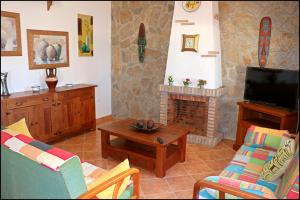 salon z kominkiem i telewizorem w obiekcie Chalet con piscina privada w mieście Conil de la Frontera +22 zdjęcia