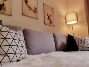 ein Wohnzimmer mit einem Sofa mit Kissen und einer Lampe in der Unterkunft Ferienwohnung Sonnenhang in Pfronten