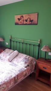 1 dormitorio con 1 cama y una pintura en la pared en Apartamento Erta, en Pla de l'Ermita