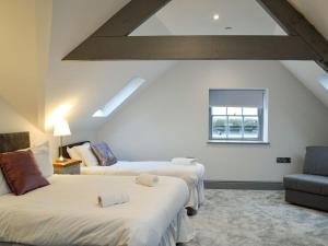 a attic room with two beds and a window at Grosvenor House APT 2 in Aberystwyth