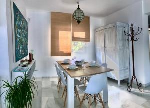 a dining room with a wooden table and white chairs at Villa Blanca Views & Pool in San José