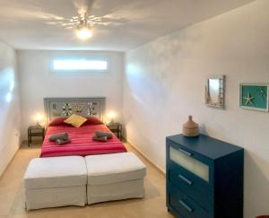 a bedroom with a red bed and a blue dresser at Villa Blanca Views & Pool in San José