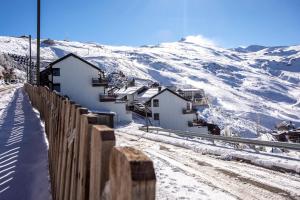 a snow covered mountain with houses and a fence at Nirvana in Sierra Nevada
