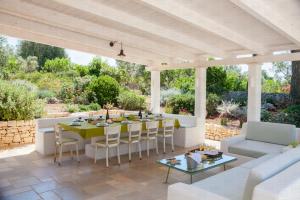 un patio con tavolo, sedie e divano di HelloApulia Trullo Amore Mio a Ceglie Messapica