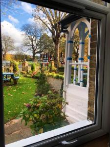 a window with a view of a park with a tree at Caspian Hotel in London
