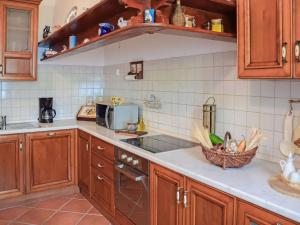 a kitchen with wooden cabinets and a basket of vegetables at Holiday Home Lea by Interhome in Rukavac