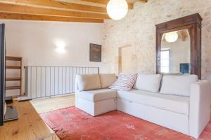 Una sala de estar con un sofá blanco y un espejo. en Ca Na Marreta, en Porreres