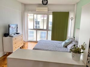 1 dormitorio con 1 cama, TV y ventana en Beautiful & Quiet Studio in Palermo - Recoleta en Buenos Aires