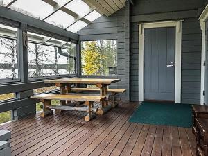 eine Veranda mit einem Holztisch und Bänken darauf in der Unterkunft Holiday Home Kallentupa by Interhome in Ruka