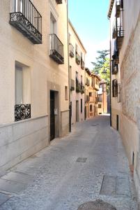 an empty street in an alley between buildings at Hospedaje La Judería in Segovia