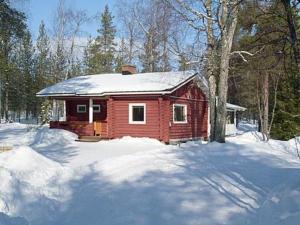 uma pequena cabana vermelha com neve no chão em Holiday Home Koppelokangas by Interhome em Kivitaipale