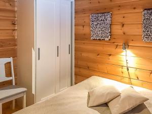 Holiday Home Metsä-vuosseli rukalumous by Interhome في روكا: غرفة نوم بسرير وجدار خشبي