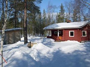 uma pequena cabana vermelha na neve com árvores em Holiday Home Koppelokangas by Interhome em Kivitaipale