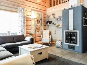 a living room with a couch and a fireplace at Holiday Home Aamunkoi by Interhome in Veskoniemi