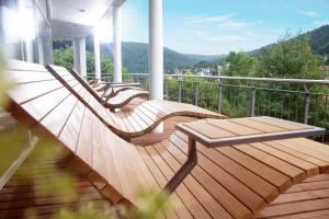 eine Veranda mit Holzbänken auf dem Balkon in der Unterkunft Schwarzwald Panorama in Bad Herrenalb