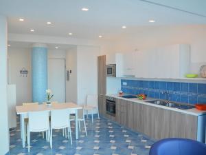 cocina con mesa y suelo de baldosa azul en Apartment Appartamento 2 by Interhome, en Porto Badino