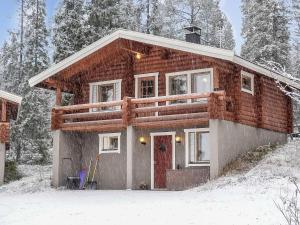 a house with a red door in the snow at Holiday Home Oloskammi 5 by Interhome in Muonio