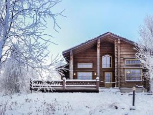 a log cabin in the snow with a fence at Holiday Home Aamunkoi by Interhome in Veskoniemi +29 photos