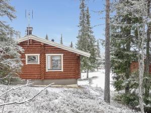 una cabaña de madera en el bosque con nieve en el suelo en Holiday Home Oloskammi 5 by Interhome, en Muonio