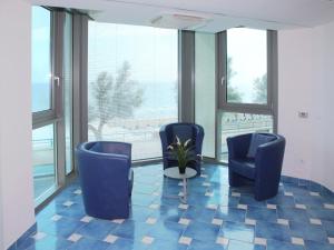 ポルト・バディノにあるApartment Residenza Fortunata-2 by Interhomeの青い椅子2脚と鉢植えの植物が備わるお部屋